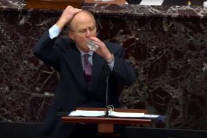 David Schoen se cubre la cabeza mientras toma un sorbo de agua en el pleno del Senado.