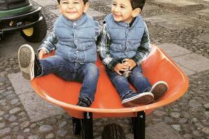 Manuel y Daniel se divierten en una carreta del rancho donde viven.
