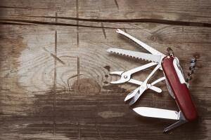 old Swiss knife on a wooden background
