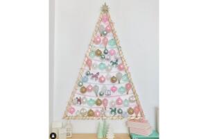 Árbol de Navidad en la pared con adornos en colores pastel