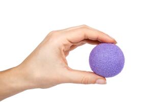 Foam rubber antistress ball, squishy relax and strength power trainer in hand. Isolated on white background