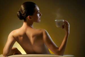 Mujer desnuda tomando infusión