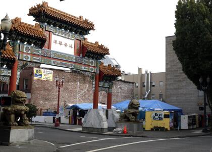 FILE - In this Oct. 4, 2013, file photo, the Right 2 Dream Too homeless camp stands next to the Chinatown gate in Portland, Ore. The Portland city council authorized officials to spend more than $254,000 to buy land in the central east side, which may be the new home for the camp currently in Portland's downtown.(AP Photo/Don Ryan, file)