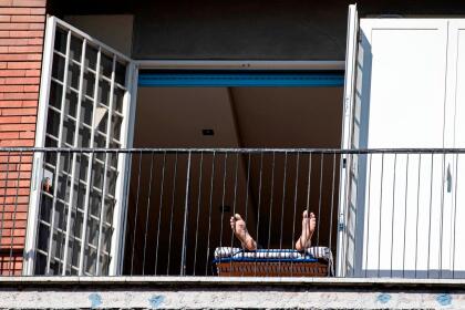 <b>Tomando el Sol.</b> Un residente de Roma recibe los rayos del Sol en la ventana mientras sigue las recomendaciones de las autoridades de no salir de casa, el 21 de marzo. Italia ya casi duplicó la cantidad de fallecidos por covid-19 que tuvo China, donde se originó el brote.