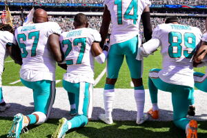Jaremy Tunsil #67, Maurice Smith #27 and Julius Thomas #89 kneel with Jarvis Landry #14 de Miami Dolphins se arrodillan durante el himno nacional en un juego contra los New York Jets el 24 de septiembre en Nueva Jersey.