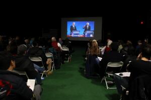Grupo de personas mira el debate en un gimnasio de Manchester, New Hampshire.