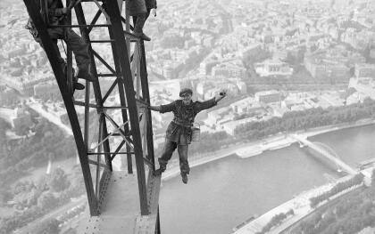 Una foto de 1924 que muestra a obreros trabajando en la Torre Eiffel para volver a pintar la gran estructura de acero. La Torre Eiffel tiene 984 pies de altura y consiste en un armazÃ³n de hierro apoyado en cuatro pilares desde donde se alzan cuatro columnas que se unen para formar una sola torre vertical. 
<br>