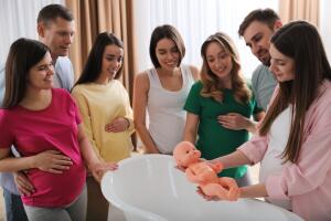 Pregnant,Women,With,Men,Learning,How,To,Bathe,Baby,At