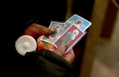 A faithful holds stamps with images of Saint Judas Tadeo to be blessed at Saint Hipolito church in Mexico City, on October 27, 2011. Thousands of faithful conmemorate the birthday of Saint Judas Tadeo on October 28th and come to the church to thank him for miracles. AFP PHOTO/Yuri CORTEZ (Photo credit should read YURI CORTEZ/AFP/Getty Images)