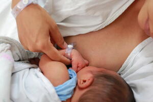 Close up mother breast feeding her newborn child.