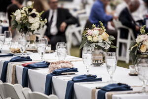 Table set up for wedding reception with people out of focus in background.