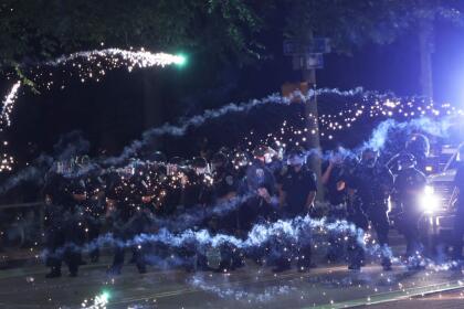 ROCHESTER, NEW YORK - SEPTEMBER 04: Fireworks go off in front of police officers as they attempt to clear the streets after a march for Daniel Prude on September 04, 2020 in Rochester, New York. Prude died after being arrested on March 23, by Rochester police officers who had placed a "spit hood" over his head and pinned him to the ground while restraining him. Mayor Lovely Warren announced yesterday the suspension of seven officers involved in the arrest. (Photo by Michael M. Santiago/Getty Images)