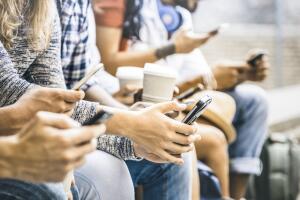 Multicultural friends group using smartphone with coffee at university college break - People hands addicted by mobile smart phone - Technology concept with connected trendy millennials - Filter image