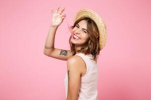 Portrait of a girl in summer hat looking at camera
