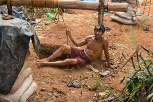 A miner rests after hours of exhausting work in makeshift tunnels. Credit: Courtesy Bram Ebus / InfoAmazonia