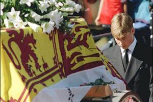 Prince William walks with his head bowed