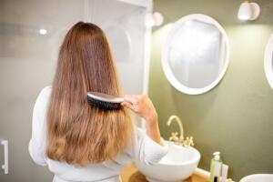 Woman combing hair in the bathroom