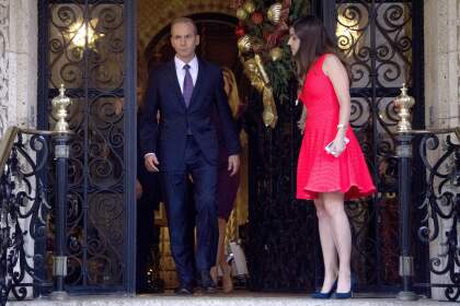 Boeing CEO Dennis Muilenburg (L) is escorted out by Madeleine Westerhout (R) or the Republican National Committee (RNC) after a meeting with US President-elect Donald Trump at Mar-a-Lago in Palm Beach, Florida on December 21, 2016. / AFP / JIM WATSON (Photo credit should read JIM WATSON/AFP/Getty Images)