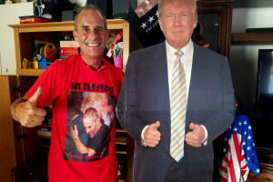 Gene Huber posa en el salón de su casa junto con una réplica de cartón de tamaño real del presidente Donald Trump.
