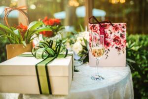 Gifts at wedding / birthday party and a glass of white wine. Celebration concept.