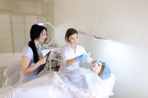 Girl of permanent tattoo artist demonstrates to female student h