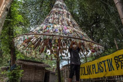 An Indonesian activist from ECOTON (ecological observation and wetland conservation) prepares an installation made with used plastic, including 4,444 bottles, collected from the river in Gresik on September 17, 2021, to raise public awareness of plastic waste in rivers and oceans. (Photo by JUNI KRISWANTO / AFP) (Photo by JUNI KRISWANTO/AFP via Getty Images)