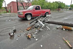 A man drives past by a fallen lamp post