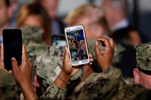 A soldier takes a photo as U.S. President Donald Trump and first lady Melania Trump interact with military personnel aboard the USS Wasp during a Memorial Day Address in Yokosuka