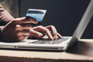 Man shopping online using laptop computer and credit card