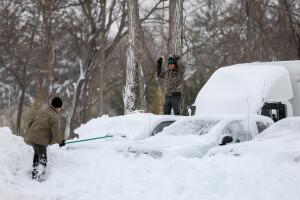 Un hombre limpia su coche de la nieve en Washington. 