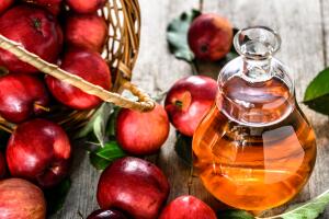 Wine bottle or apple cider vinegar, healthy detox drink with organic red apples on table