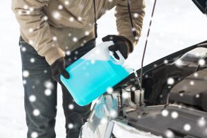 closeup of man pouring antifreeze into car