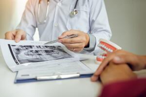 Real estate agent hand showing customer where to writing sign a contract of house or mortgage papers.