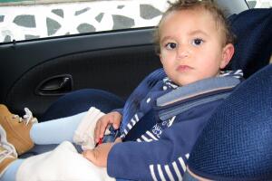 Toddler sitting in car seat.