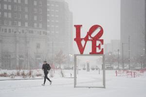 Una persona corre en JFK Plaza, también conocido como Love Park, durante una tormenta invernal en Filadelfia.