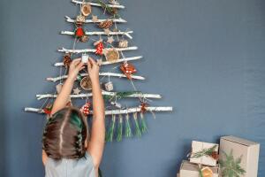 Niña decorando un árbol de Navidad en la pared