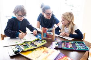 Niños haciendo la tarea junto a su mamá