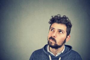Suspicious young man looking up