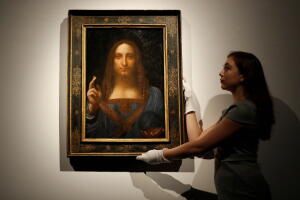 Una persona del staff de la casa Christie's sostiene la obra del maestro Da Vinci subastada este miércoles.