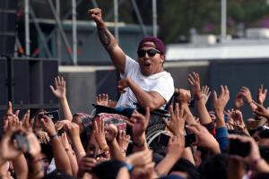 Usuario de silla de ruedas siendo cargado por la multitud durante el festival Vive Latino, en México