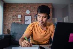 Asian businessmen is using notebook computers and wear headphones for online meetings and working from home.