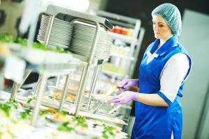 buffet female worker servicing food in cafeteria