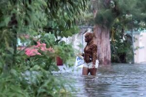 A woman walks in a flooded street after the effects of Hurricane Dorian arrived in Nassau