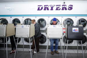 Tres personas emiten sus votos en la lavandería Su Nueva en Chicago, Illinois.