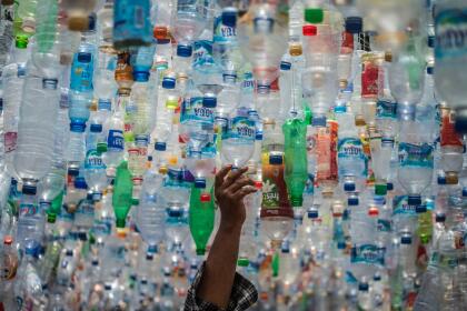 TOPSHOT - An Indonesian activist from ECOTON (ecological observation and wetland conservation) prepares an installation made with used plastic, including 4,444 bottles, collected from the river in Gresik on September 17, 2021, to raise public awareness of plastic waste in rivers and oceans. (Photo by JUNI KRISWANTO / AFP) (Photo by JUNI KRISWANTO/AFP via Getty Images)