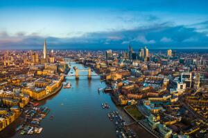 London, England - Panoramic aerial skyline view of London including Tower Bridge with red double-decker bus, Tower of London, skyscrapers of Bank District