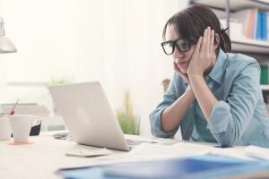 Mujer aburrida frente a la computadora