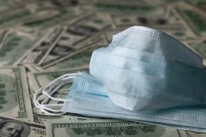 edical face mask and dollar banknotes, world coronavirus epidemic and economic losses concept.