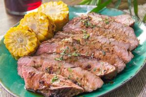 carne asada jugosa acompañada de elotes