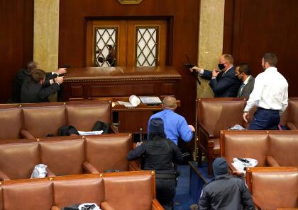 (FOTOS) PRIMERA VEZ EN LA HISTORIA DE EEUU QUE PASA EN EL CAPITOLIO 40 WASHINGTON, DC - JANUARY 06: U.S. Capitol police officers point their guns at a door that was vandalized in the House Chamber during a joint session of Congress on January 06, 2021 in Washington, DC. Congress held a joint session today to ratify President-elect Joe Biden's 306-232 Electoral College win over President Donald Trump. A group of Republican senators said they would reject the Electoral College votes of several states unless Congress appointed a commission to audit the election results. (Photo by Drew Angerer/Getty Images)